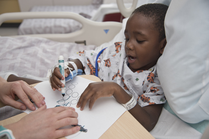 Williams works on writing skills, learning the letters of the alphabet.