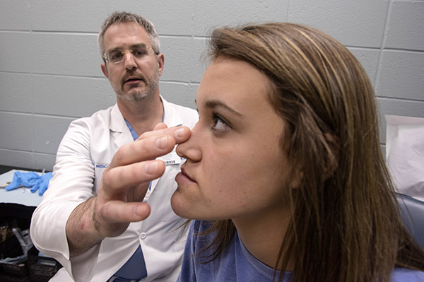 Caloss examines Cook’s face prior to surgery.