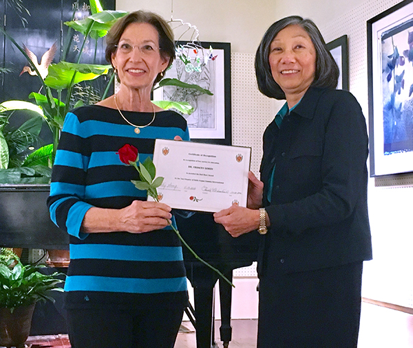 Gordy, left, receives the Red Rose Award from Betty Wong, Red Rose Award Committee chairperson, Tau Chapter Delta Kappa Gamma.