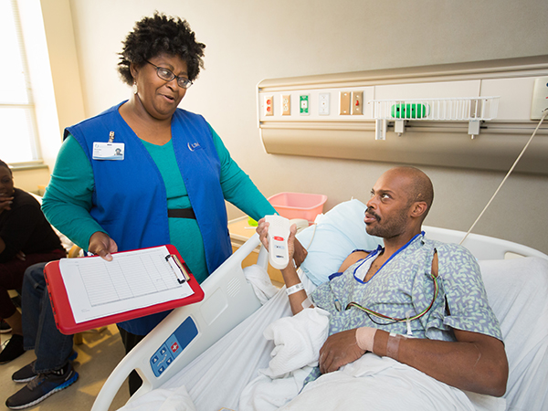 Moseziner “Mo” Crozier, a UMMC volunteer, checks in on Charles Palm Boyd of Morton.