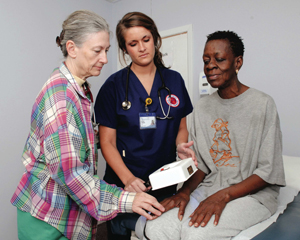 Dr. Barbara Boss, left, professor of nursing, and senior nursing student Kathryn Dambrino, center, examine midtown resident Jessie Lee Butler.