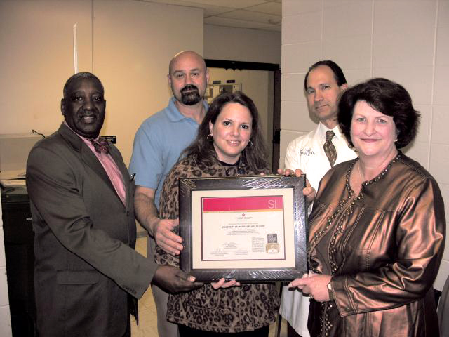 Earl Coleman, left, of the American Heart Association presents a Get With the Guidelines-Stroke Bronze Award to members of University Neurosciences-Stroke Care, from left, Dr. Hartmut Uschmann, associate professor of neurology; Kim Stonecypher, clinical director of nursing services; Dr. Alexander P. Auchus, professor of neurology; and Ginnie Ingram, manager of the stroke program.