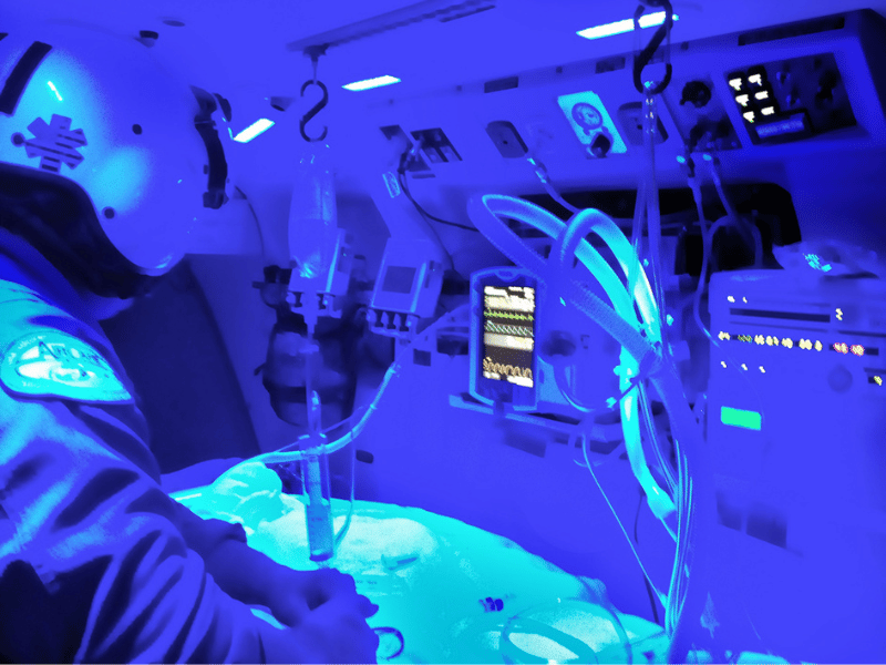 AirCare flight critical care paramedic Jeremy Benson monitors a critically ill patient who is on a ventilator during a recent flight to the University of Mississippi Medical Center. Paramedics onboard the medical flight helicopter often wear night-vision goggles and use a blue-tinted interior light, which allows them to navigate safely to inter-facility transports or emergency scenes.