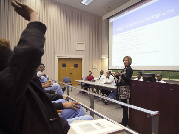 A student, far left, prepares to pose a question for Dr. LouAnn Woodward