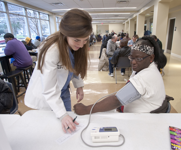 Megan Henry checks the blood pressure of Grace Place visitor Tonya Austin Williams.