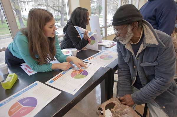 Rosemary Moak, left, and Kara Avery, center, dole out healthy-eating information to Grace Place visitors, including, Charles King, right.