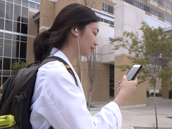 Second-year University of Mississippi School of Medicine student Cathy Chen uses earbuds to listen to music on her cell phone.