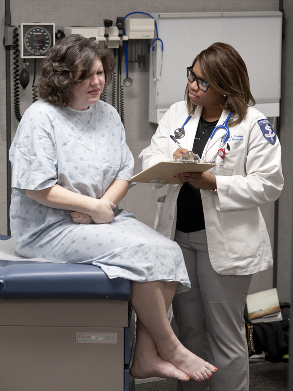 Walling, left, describes her medical complaints -- according to her script -- to Wilfreda Lindsey, a second-year medical student.