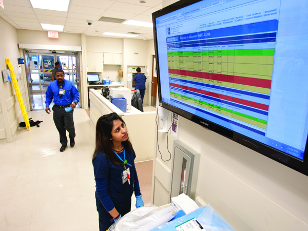 Deepali Bhatt, an emergency room technician, stops to scan an electronic board that details patients en route via ambulance to the Emergency Department.