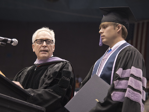 School of Dentistry Dean Gary Reeves gives the Wallace V. Mann Jr. Award to graduate Michael Cole Collier.