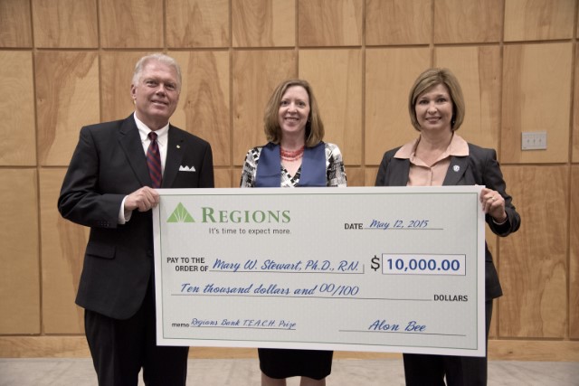 Bee, left, and Woodward, right, present the ceremonial TEACH Prize check to Stewart.