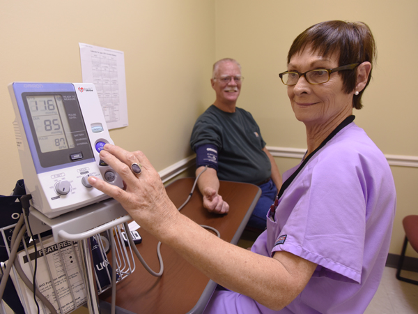 Cathy Adair, clinical research manager, checks the blood pressure of Lamar Adair (no relation) as part of the SPRINT study. Lamar was part of the 140/90 mm Hg treatment group.