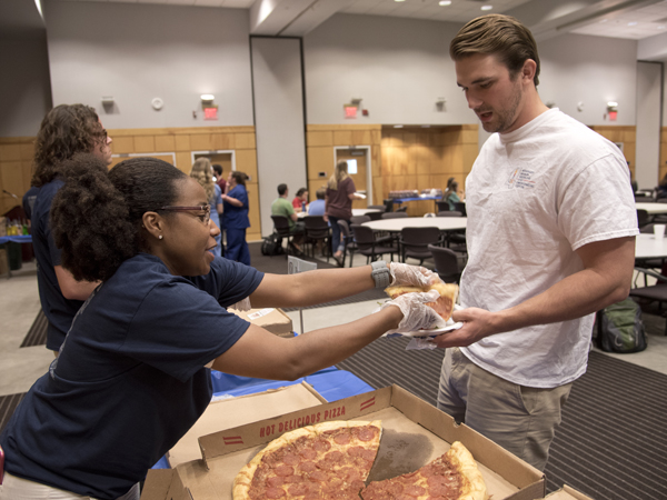 Kandis Backus, a pharmacy student and STARS member, serves Jacob Daniels, a physical therapy student, during the Office of Alumni Affairs’ Sept. 10 “It Begins with U” event at the Student Union.