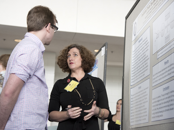 Stephen explains her research into pediatric pain control to Aaron Poole, a biochemistry graduate student.