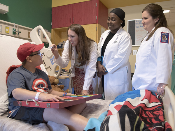 Hematology/Oncology fellows, Dr. Laura Newman, left, Dr. Hafsat Mashegu and Dr. Amanda Strobel, visit the bedside of oncology patient Andrew McCall of Philadelphia, Miss.