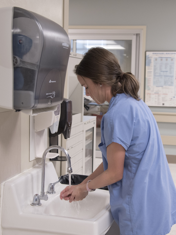 UMMC cardiovascular intensive care nurse Taylor Vick takes time to wash her hands before entering a patient's room.