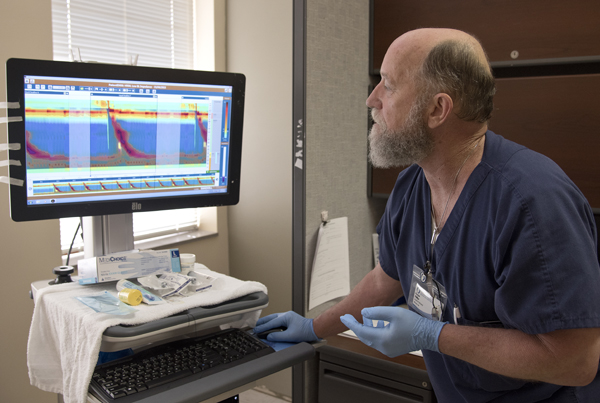Phillips looks at images that show the pressure of a patient's swallowing motions.