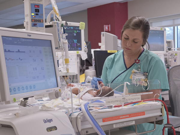 Jennifer Hill, a registered nurse in the NICU, takes the temperature of a tiny baby. Hill has been a nurse for about two years.