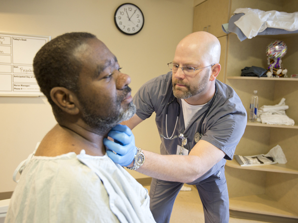 Shane Wilbourne (right) checks kidney transplant recipient Gregory Rodgers of Canton to make sure he's ready to be discharged.