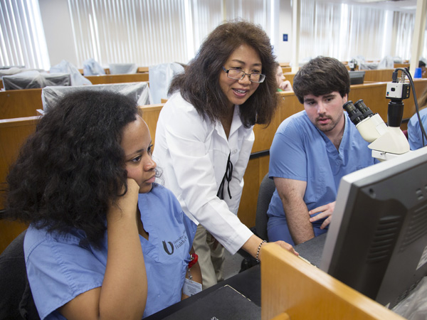 Bailey, left, and her lab partner Austin Henderson, right, are schooled in histology by Dr. Dongmei Cui.