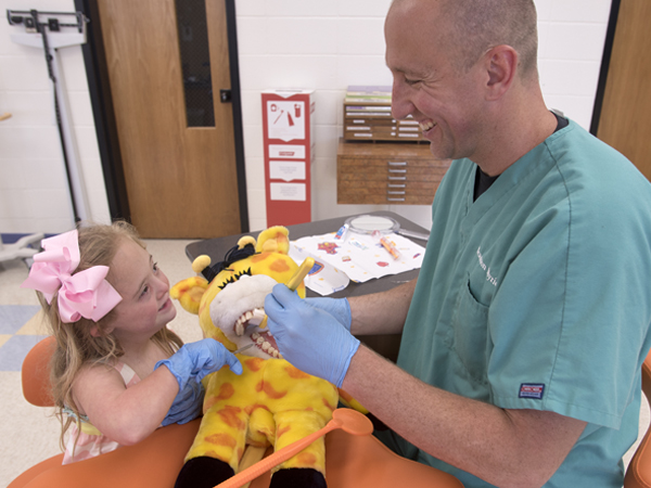 Seeing a Smile Train advertisement in a magazine while attending therapy with his daughter, Leighton, left, led Myrick to consider a career in dentistry.