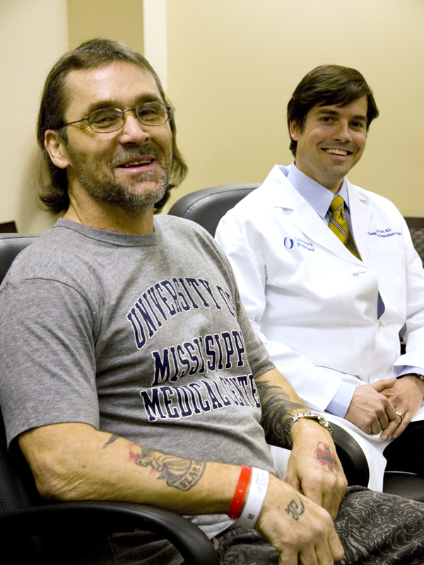 Paul Davis, who received a pancreas and kidney from organ donor Jamison White, sits beside Dr. Mark Earl, associate professor of transplant surgery, during a news conference about the surgery Dec. 16, 2013