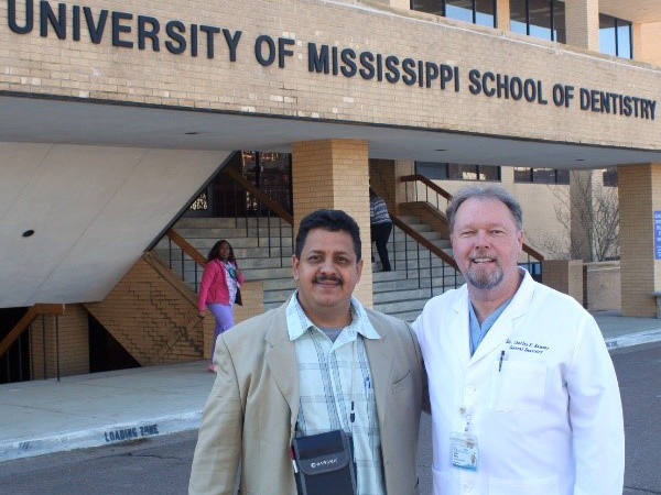 Dr. Raphael Samos, left, the senior dental surgeon for the country of Belize, stands with Ramsey in front of the School of Dentistry.