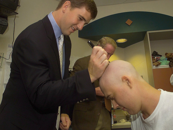 Eli signs the head of Batson patient Justin Scruggs during a visit to the children's hospital in 2004, his rookie year. Eli would write about the impromptu autograph in a letter published in The Players' Tribune. (Courtesy The Clarion-Ledger)