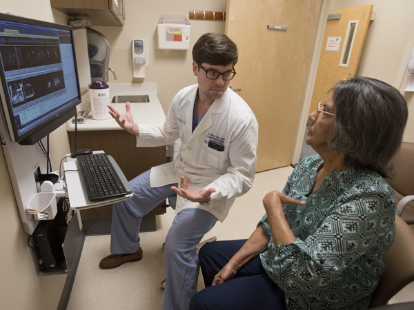 Dr. Mark Earl shows Wallace images of the cancerous liver he and his team removed and the new one that she received.