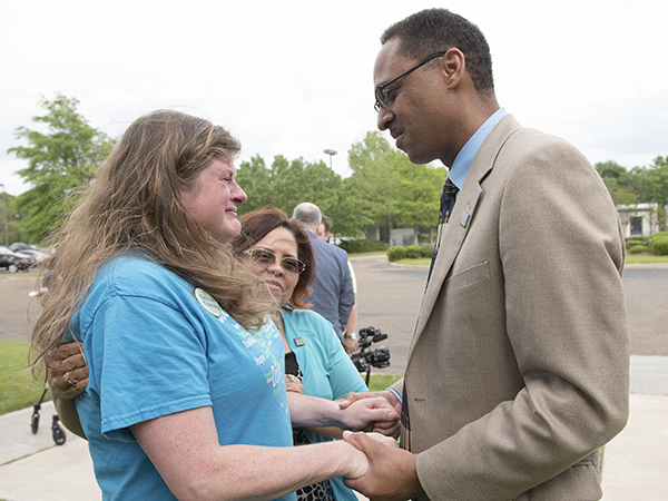 As his wife Teila looks on, heart transplant recipient Tim Lewis of Jackson tenderly holds the hands of Christina Jordan of Tupelo, who donated her son Gabriel's organs after his death in 2015.