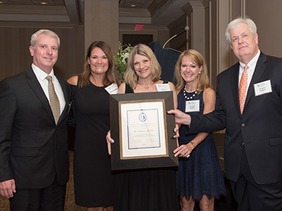 Family members of Connie McCaa accept the Hall of Fame certificate on her behalf.