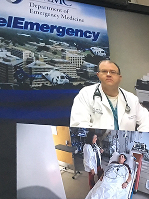 In a mock treatment scenario, Dr. John McCarter, associate professor of emergency medicine, talks via live Telemergency video connection with Genie Vaughan, an emergency room nurse practitioner at rural Franklin County Hospital in Meadville.