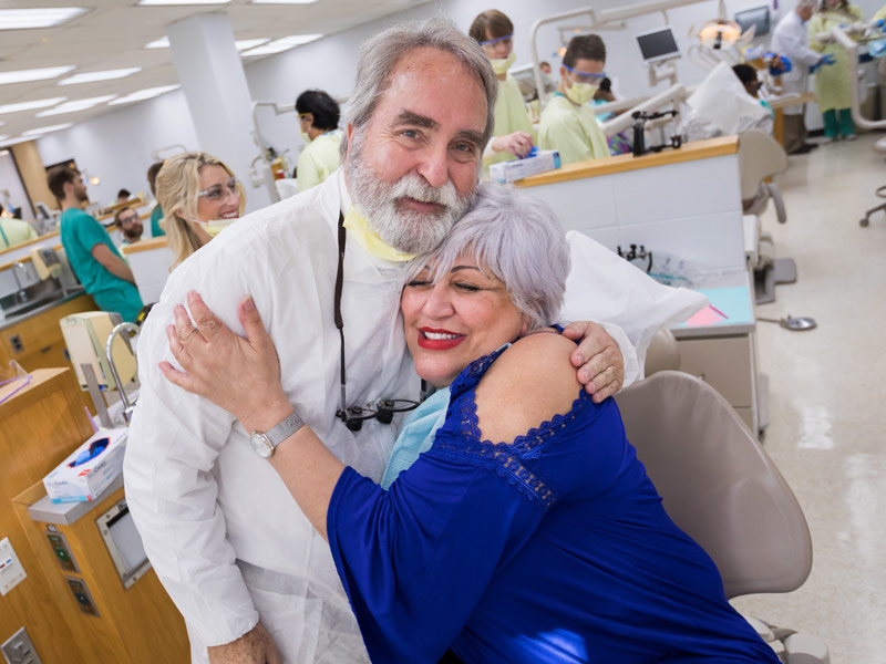 Dr. David Felton, dean of the School of Dentistry, gets a hug from Sellers in appreciation for her new dentures.