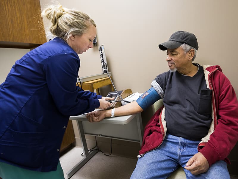 Brittany Groover, licensed practical nurse, takes patient John Hall's blood pressure.