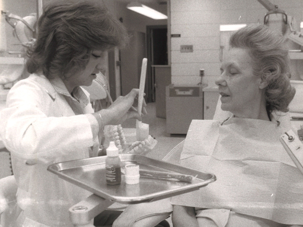 In this photo from the early 1980s, dental hygiene student Diane Forrest provides oral hygiene instruction to the school's receptionist "Ms. Annie" DeLaughter.