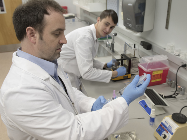 Drew Townsend, right, a fifth-year doctoral candidate in neuroscience, and Dr. Kevin Freeman, assistant professor of psychiatry and an addiction researcher, prepare to test deterrents that, if added to an opioid, make the user experience unpleasant side effects if the drug is taken in higher amounts than prescribed.