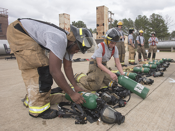 Robert Cannon, left, of Jackson and Savanna Sanchez of Natchez prepare their uniforms before entering one of several emergency scenarios during training.