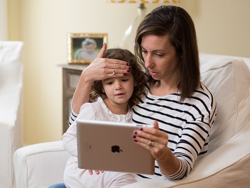 UMMC Senior Marketing Specialist Kristin Gorney demonstrates an at-home medical appointment with her daughter, Ella Grace.