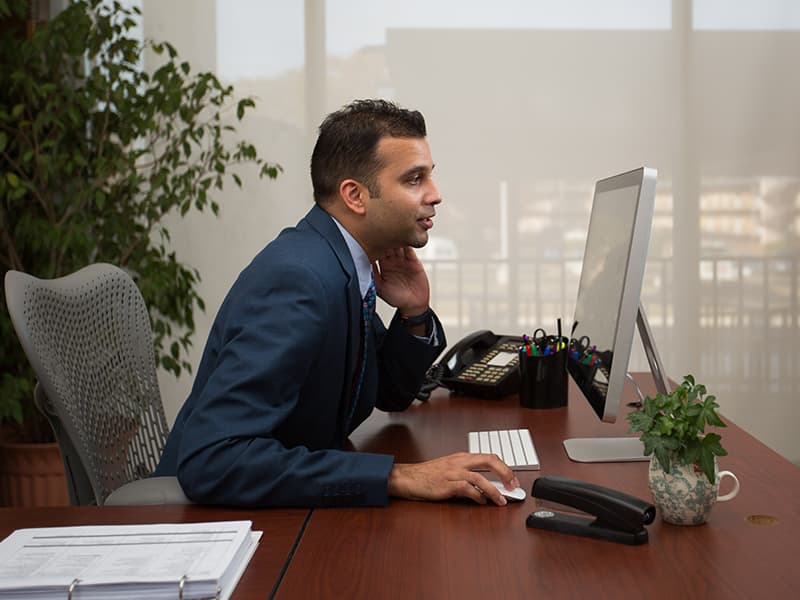 Rakesh Patel, who is completing a hospital administration residency at UMMC, talks to a telehealth provider via a desktop computer during a test of the UMMC 2 You platform from an office environment.