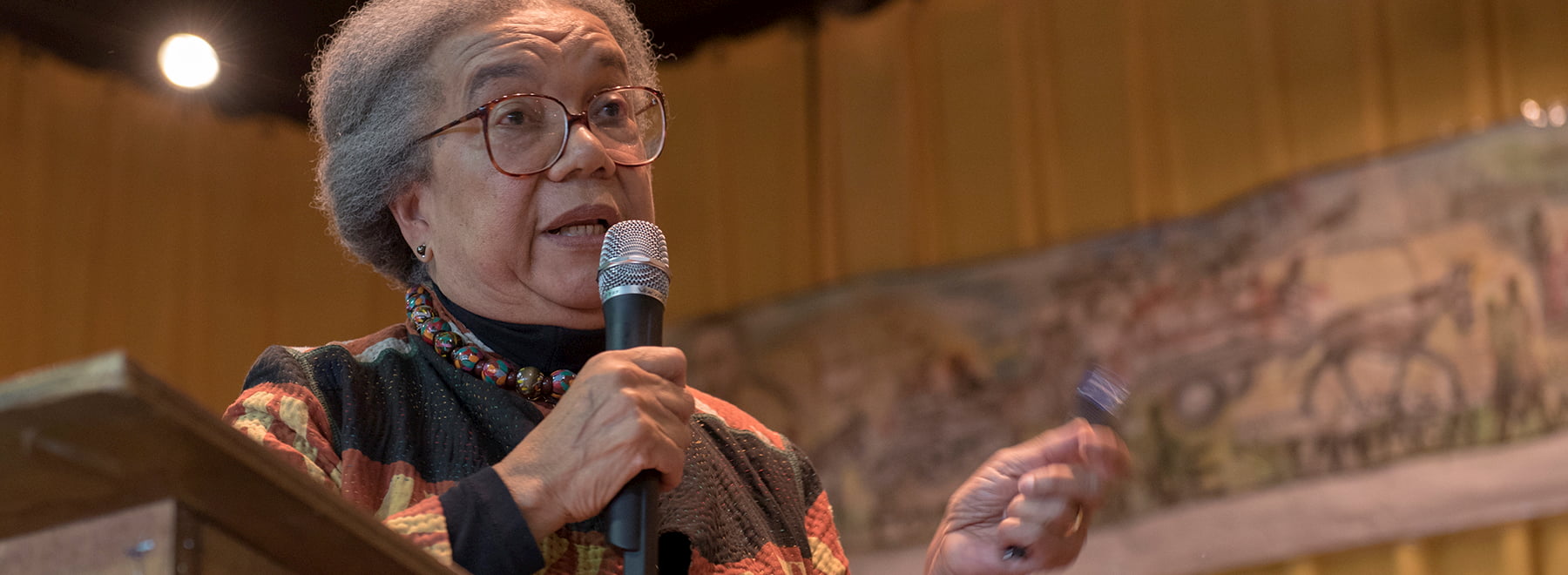 Marian Wright Edelman speaking with microphone in hand.