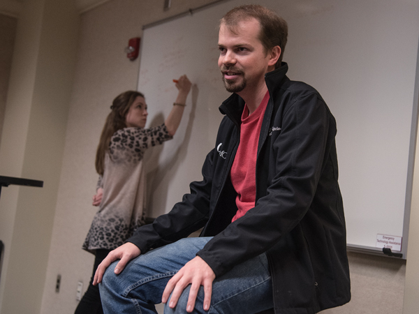 During a meeting of Medical Spanish (Club de Espanol) co-president  R.J. Case, portraying a patient, describes his "symptoms," as Mary Ball Markow lists them on the white board.