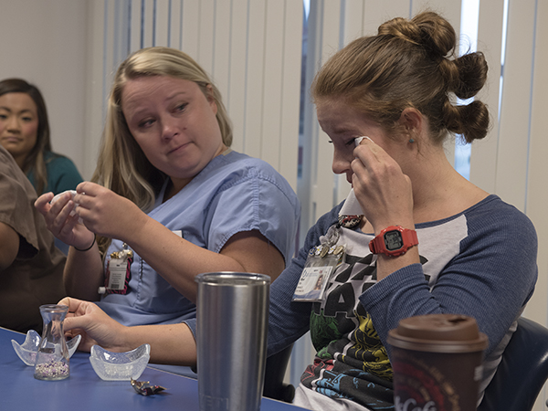 Sara Black, left, Batson Children's Hospital nurse, listens to fellow nurse Allison Kiss during a Code You debriefing session.