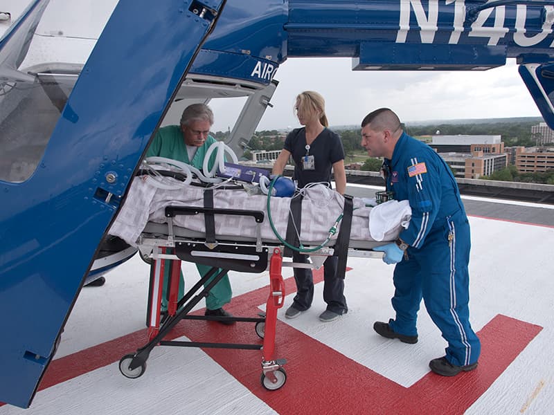 Summers, left, oversees the unloading a patient from the AirCare helicopter, with Jazz Kolb, an R.N. in the Emergency Department, and Paul Boackle, flight/transport R.N.