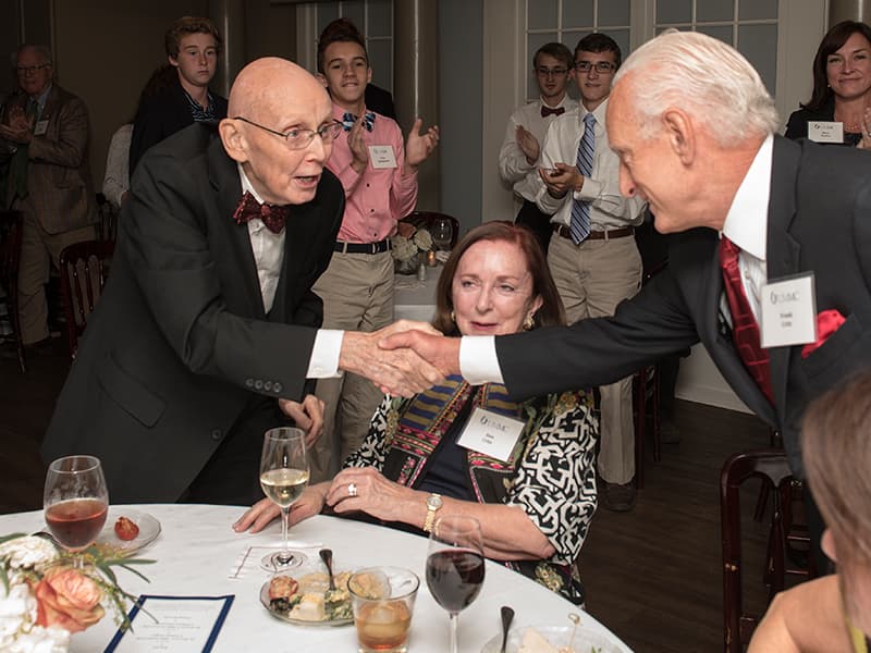 Richard, left, shakes Frank's hand in appreciation for the Critz's generous $2 million gift to UMMC's Department of Pediatrics.
