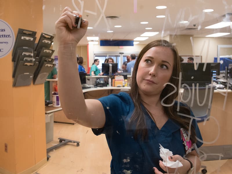 Maranda Guess, a nurse in the pediatric Emergency Department, makes notes on incoming 