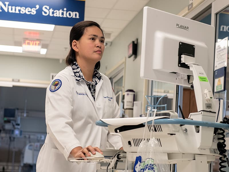 Dr. Hana Nobleza, assistant professor of neurology, checks patient records while serving in the neuroscience intensive care unit.