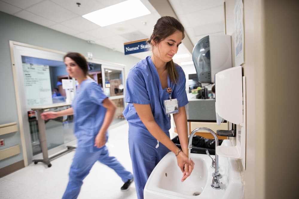Student nurse extern Anna McClain washes her hands while working in the NSICU.