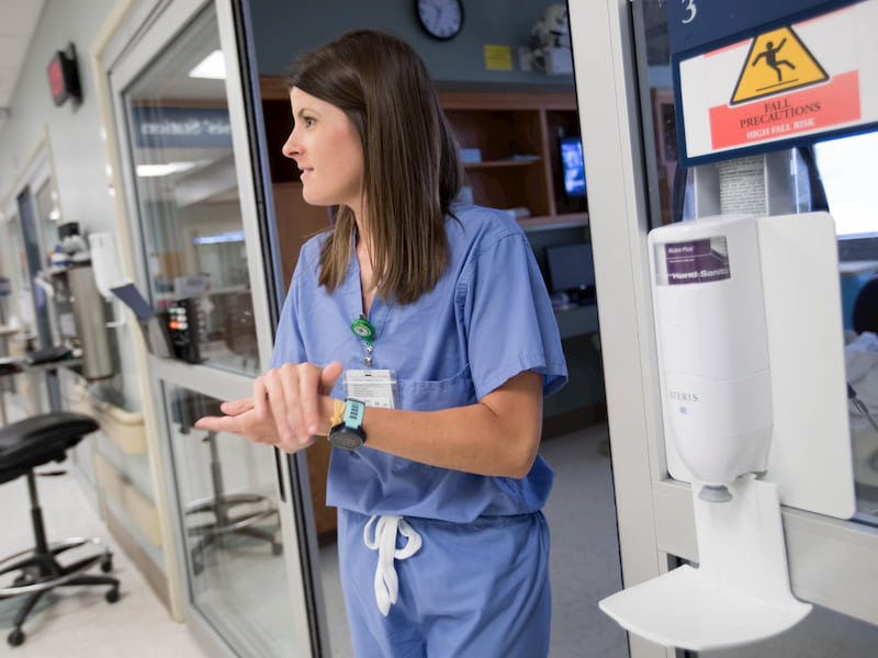 Registered Nurse Megan Bauerle foams her hands while leaving a patient room in the NSICU.