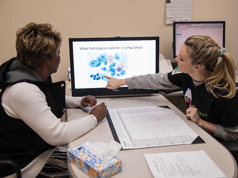 Dr. Melissa Brents, a pathology resident, reviews Pap test charts with Mangle Shanks of Jackson before showing Shanks her cervical test results at the 2017 See, Test & Treat screening.
