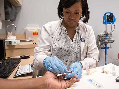 Clinical research nurse Jennifer Brumfield collects a blood sample for testing for HIV antibodies at UMMC's Express Personal Health clinic.